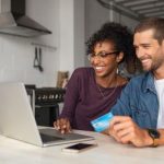 Couple using laptop to research secured vs unsecured credit cards