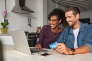 Couple using laptop to research secured vs unsecured credit cards