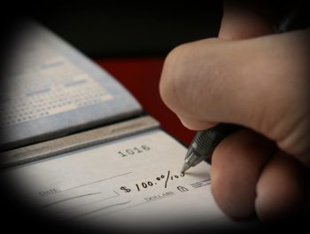 A man writes a check drawing on his checking account.