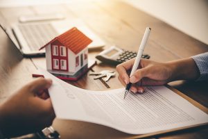 a women signs to refinance her mortgage