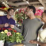 An African American couple uses a credit card to purchase flowers.