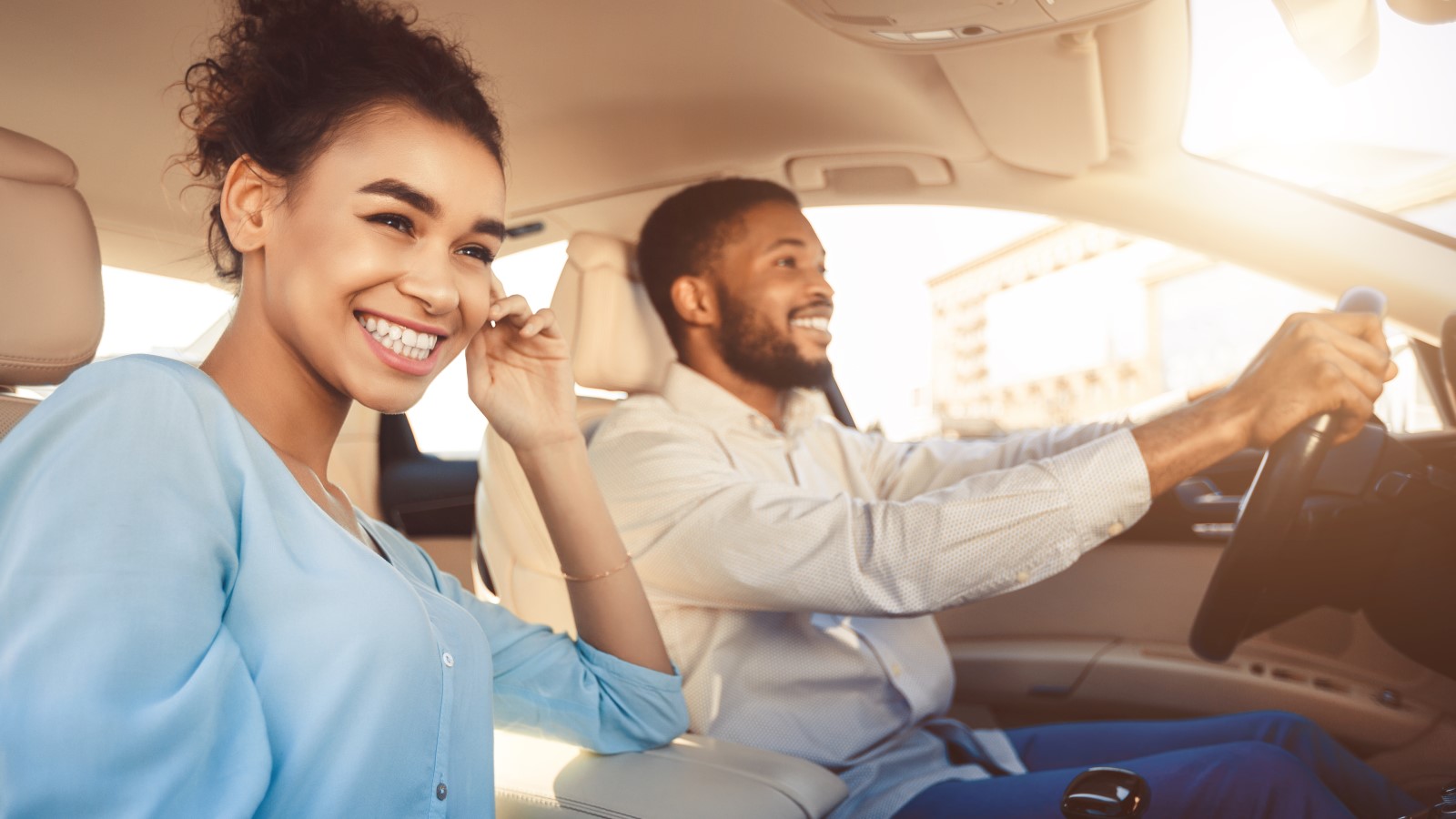 A young couple takes a drive after learning how to refinance a car loan.