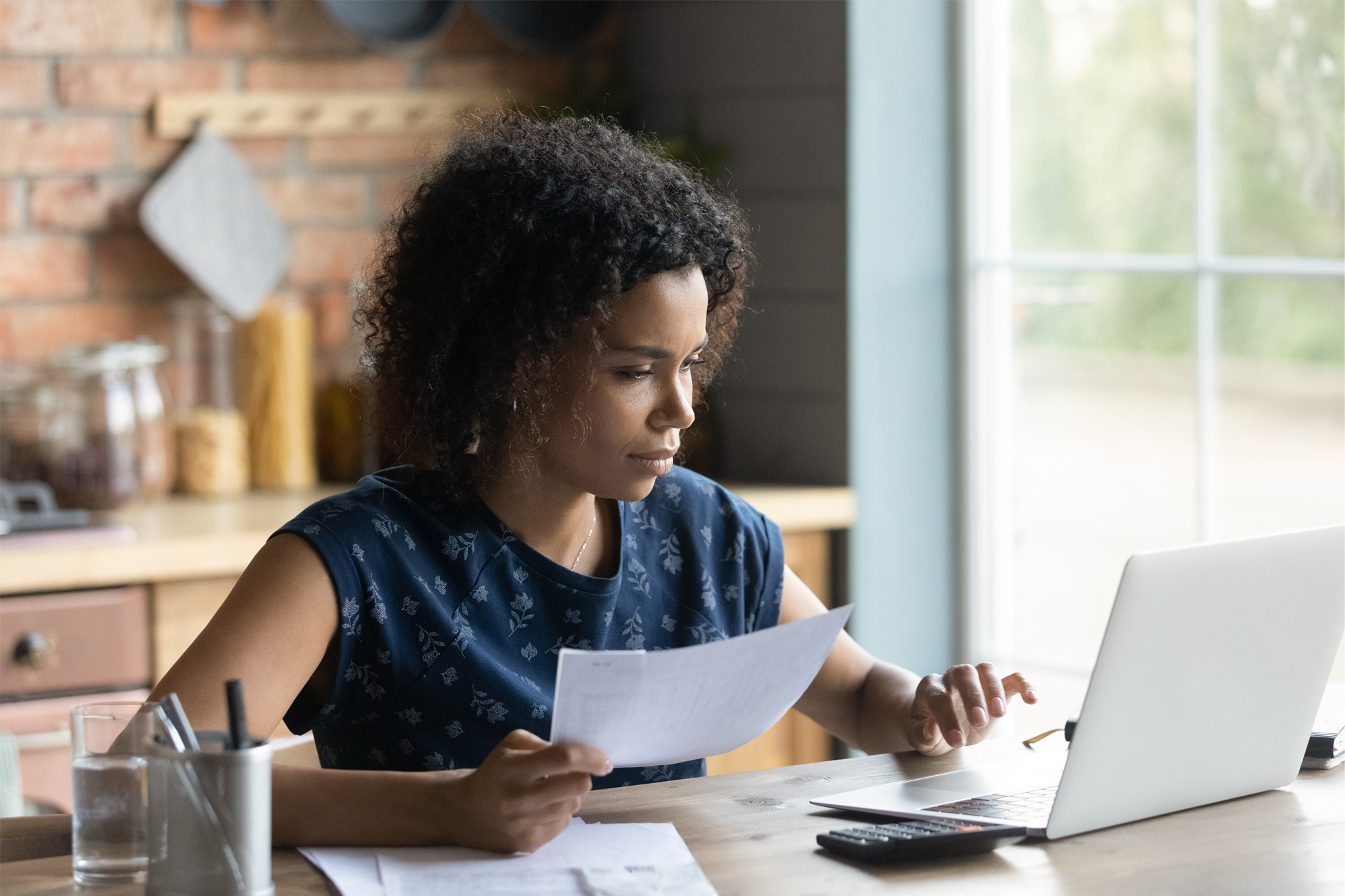 A young woman takes time to review her credit standings online after learning more about credit monitoring.