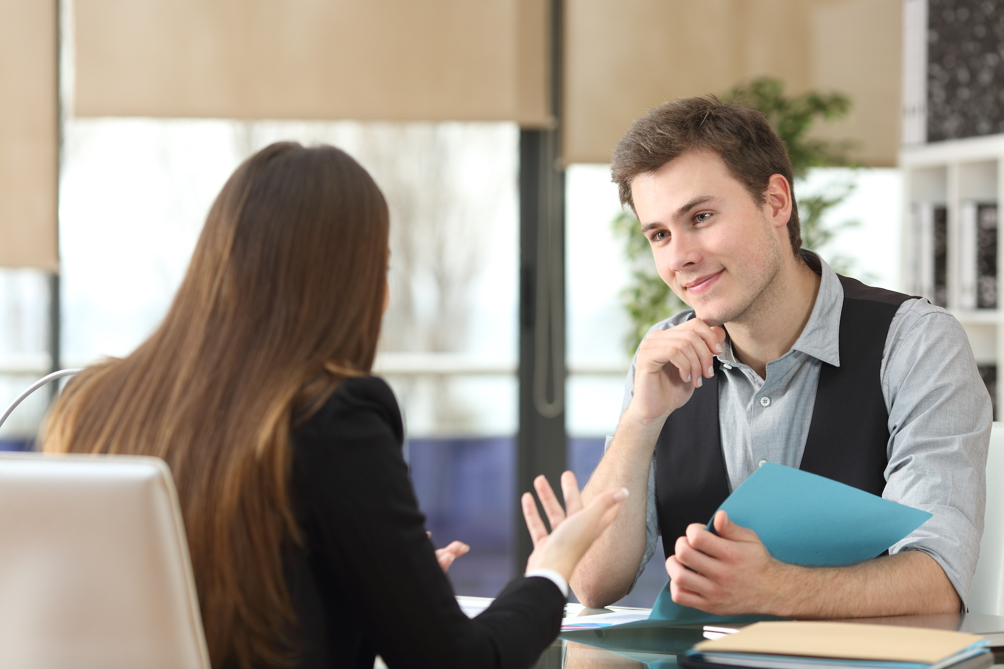 A younger man listening to a financial advisor explain how personal loans work.