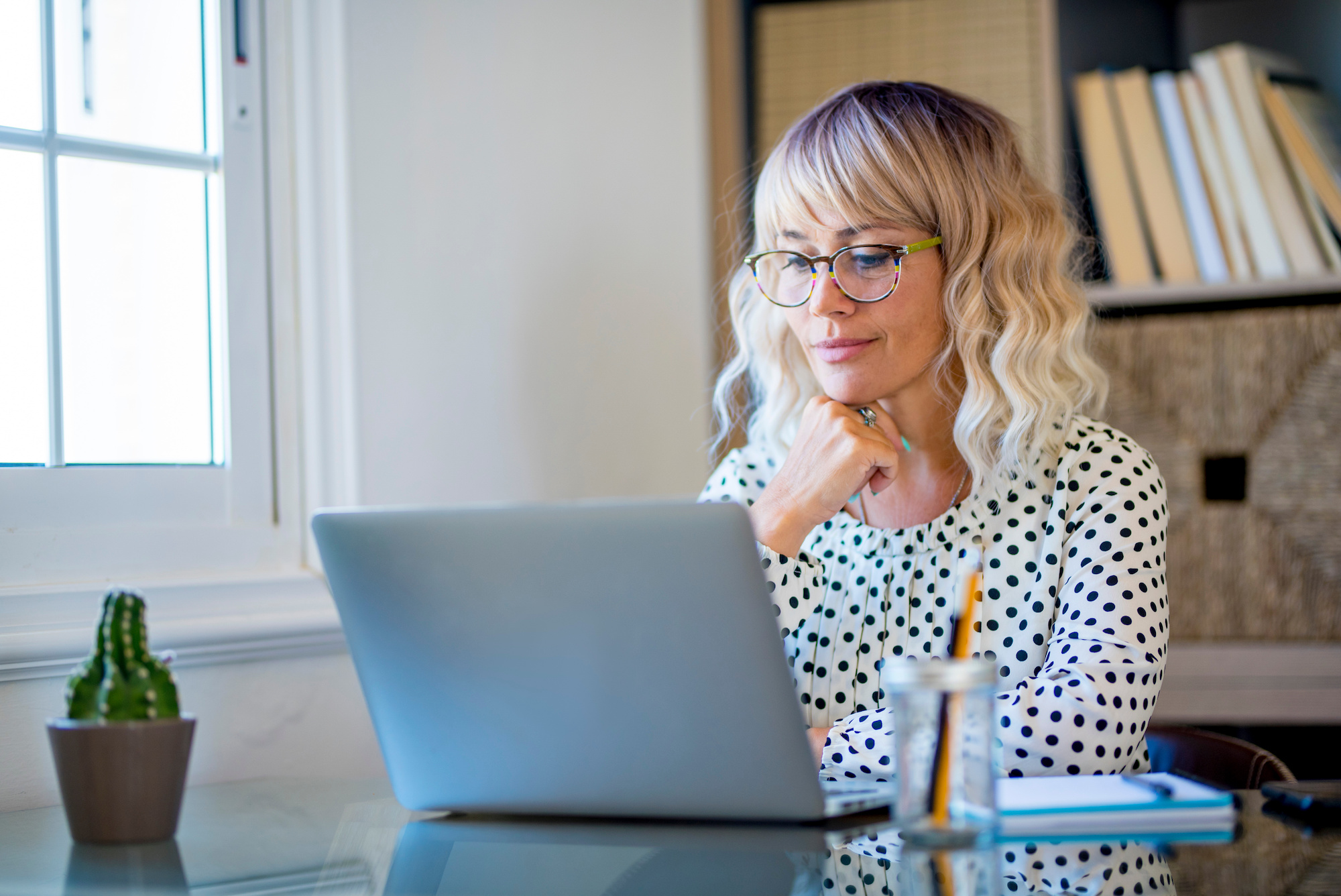 A woman doing research on her laptop about what personal loans can be used for.